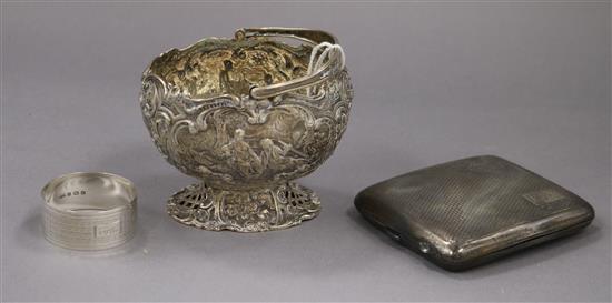 A German white metal bonbon basket, a silver cigarette case and a silver napkin ring.